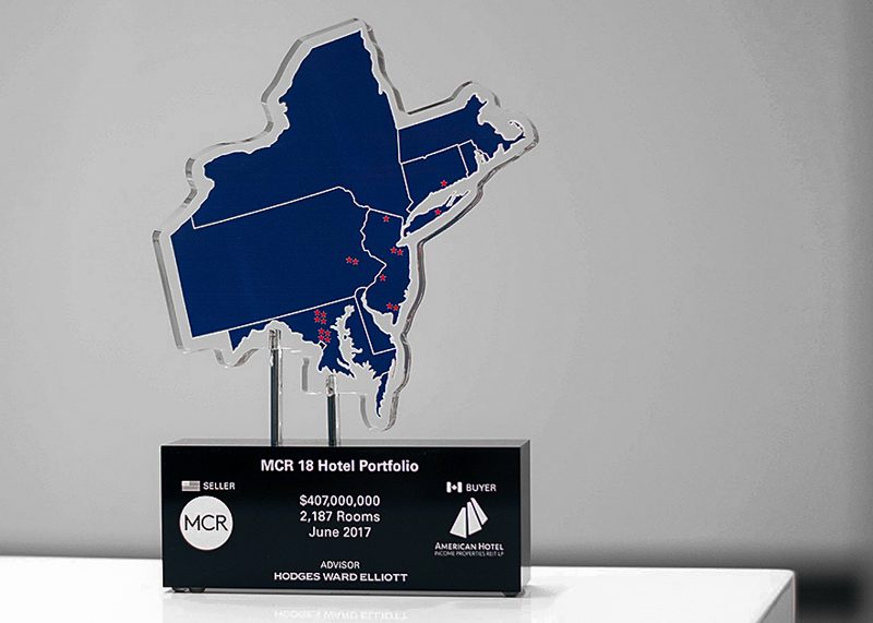 Acrylic base with metal stand offs holding up a water CNCd region shape acrylic panel.